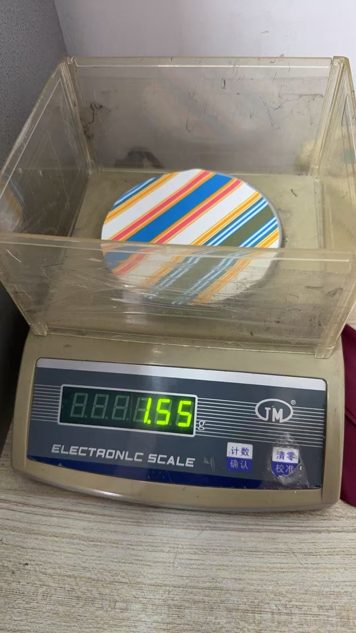 Internal 100 square centimetre fabric sample check for supplier card RY-4WP161 showing 1.55 grams on a zeroed scale