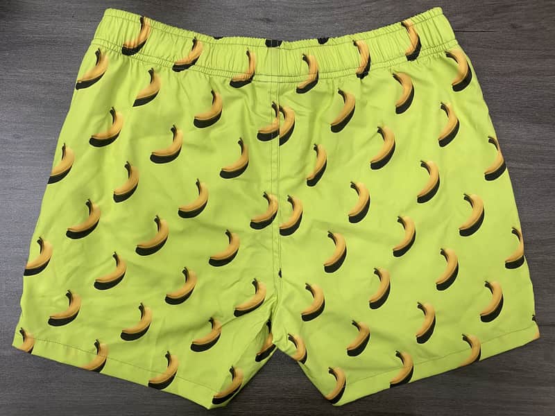 Front view of self-owned lime elastic-waist swim shorts with banana print