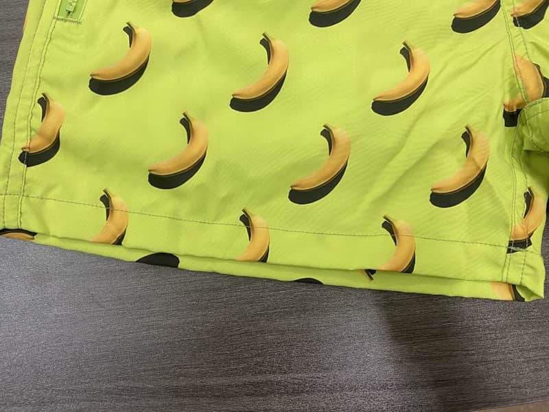 Hem and banana repeat detail on lime swim shorts