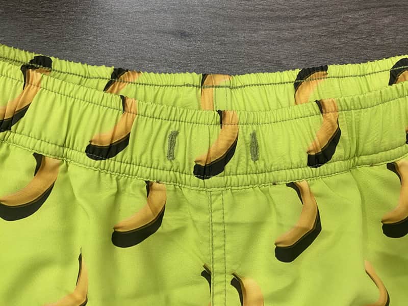 Elastic waistband and banana print detail on lime swim shorts