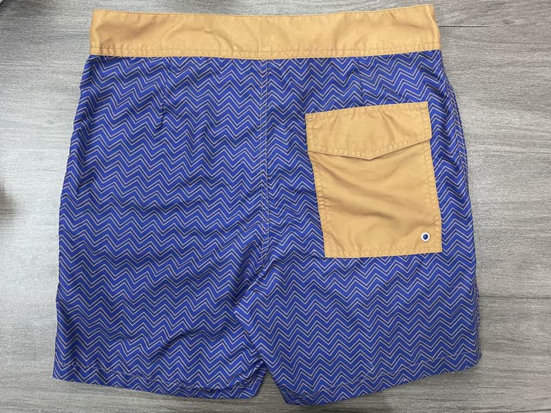 Back view of blue chevron board shorts with tan contrast pocket