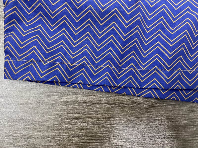 Hem and fine chevron repeat detail on blue board shorts