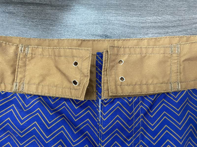 Tan waistband and fly detail on blue chevron board shorts