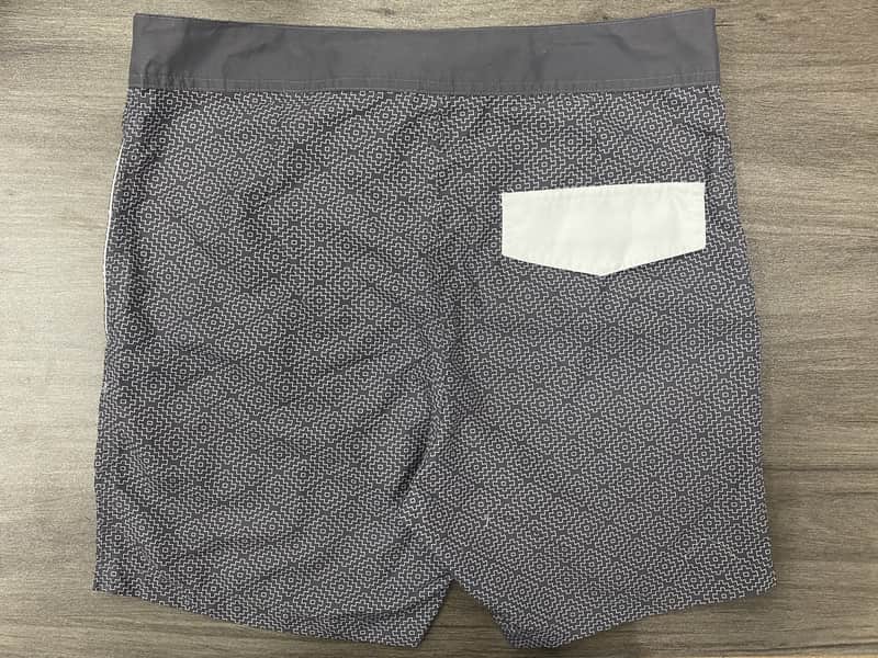 Back view of charcoal micro-geometric board shorts with contrast pocket