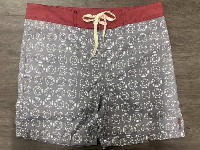 Front view of self-owned fixed-waist board shorts with gray circular geometric print