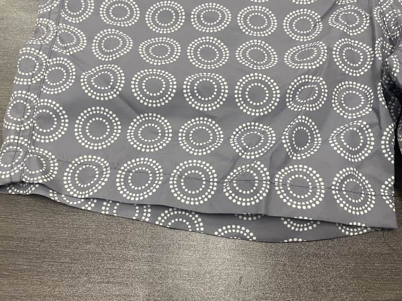 Hem and circular print detail on gray board shorts