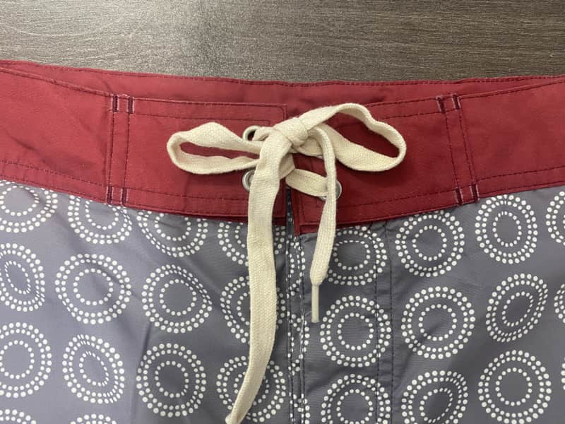 Contrast waistband and lace-up front detail on circular geometric board shorts