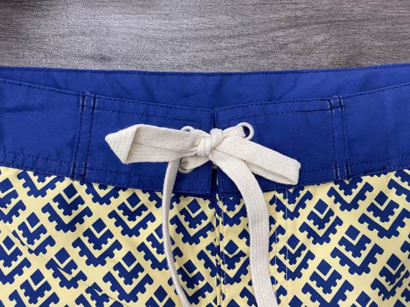 Solid waistband and drawcord detail on cobalt geometric board shorts