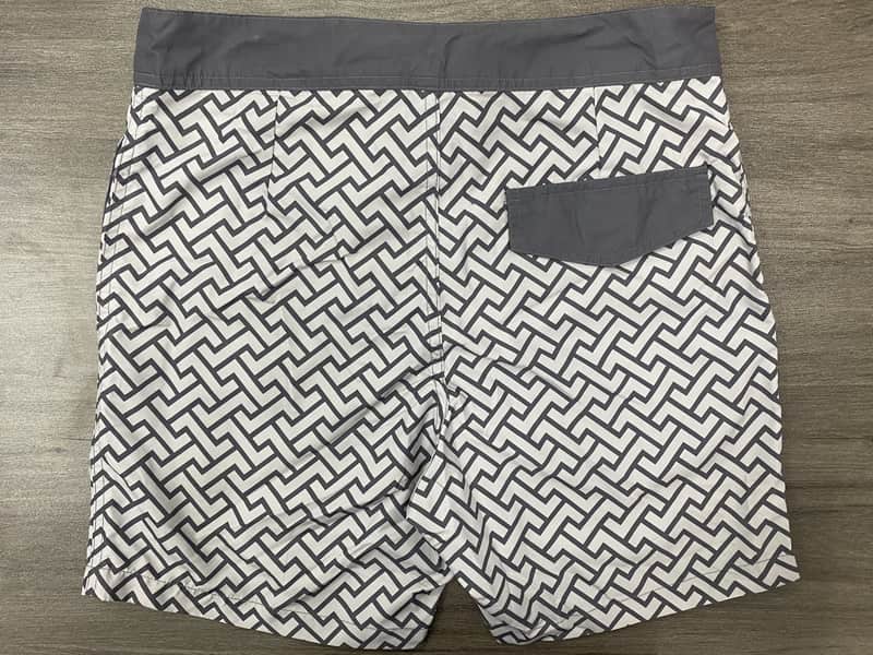 Back view of monochrome maze print board shorts with contrast pocket