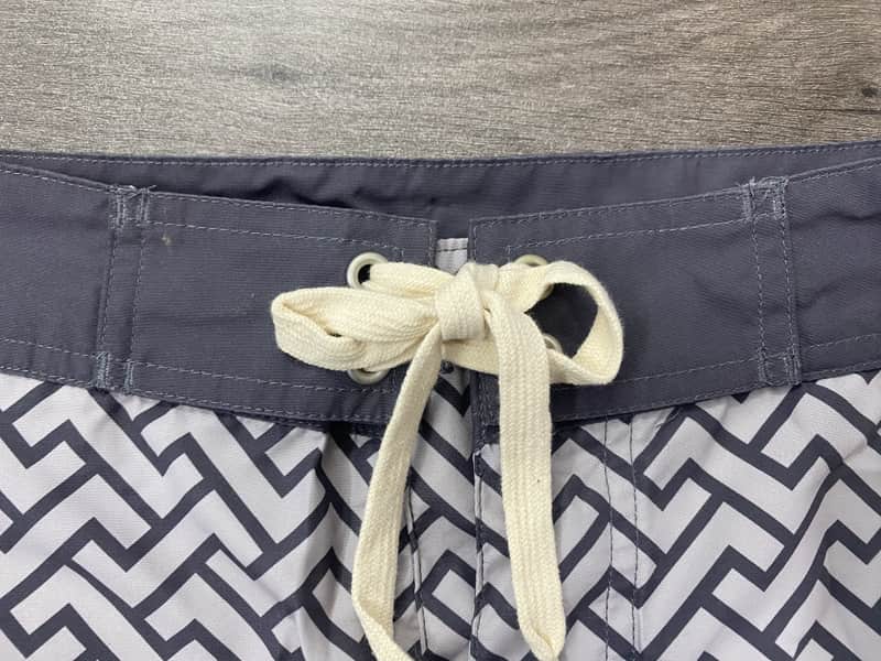 Contrast waistband and drawcord detail on monochrome maze board shorts