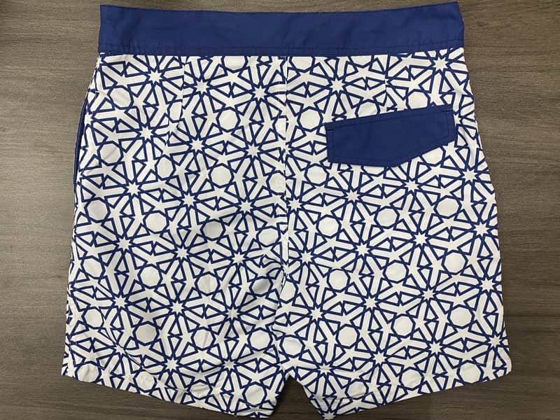 Back view of navy and white abstract board shorts with solid pocket