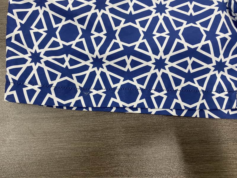 Hem and navy abstract repeat detail on board shorts