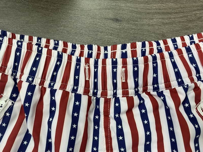 Elastic waistband detail on red navy and white striped swim shorts