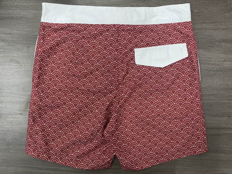 Back view of red wave print board shorts with white pocket