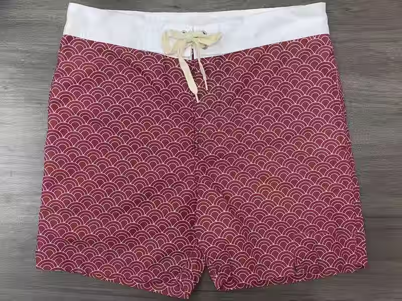 Front view of red wave print fixed-waist board shorts