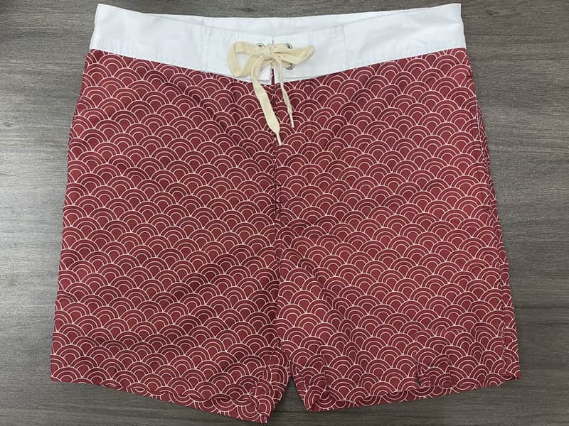 Front view of self-owned red wave print fixed-waist board shorts