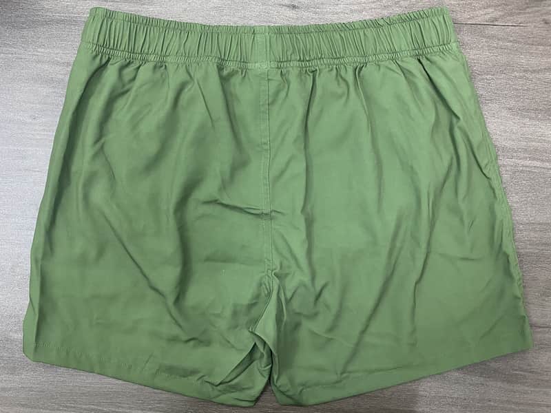 Back view of sage solid elastic-waist swim shorts