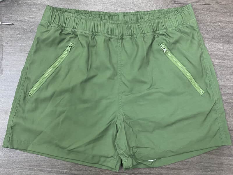 Front view of self-owned sage solid elastic-waist swim shorts with zipper pockets
