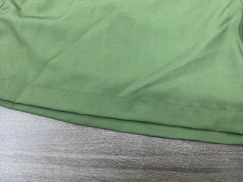 Hem construction detail on sage solid swim shorts