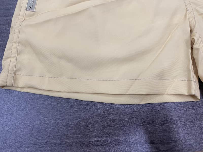 Hem construction detail on sand solid swim shorts