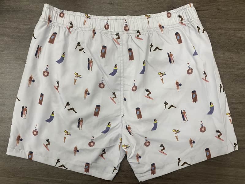 Back view of self-owned elastic-waist swim shorts with a small surfer-figure print