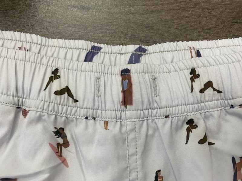 Close view of the elastic waistband on small surfer-figure print swim shorts